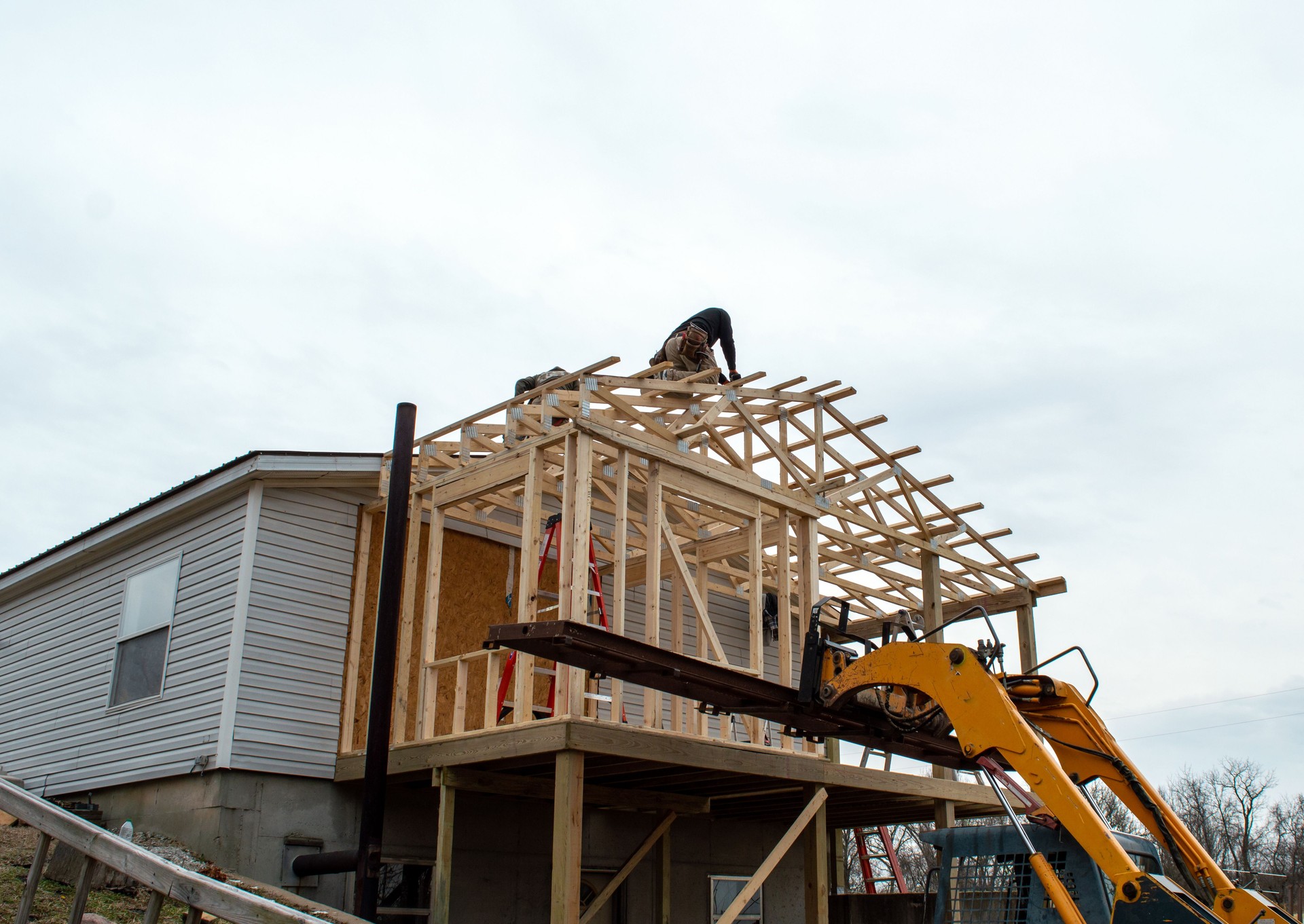 Carpenters on the roof of new building addition